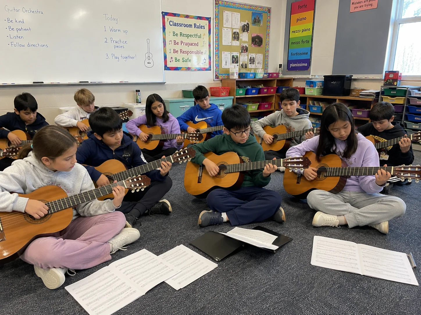 Kinderen spelen samen gitaar in een klaslokaal