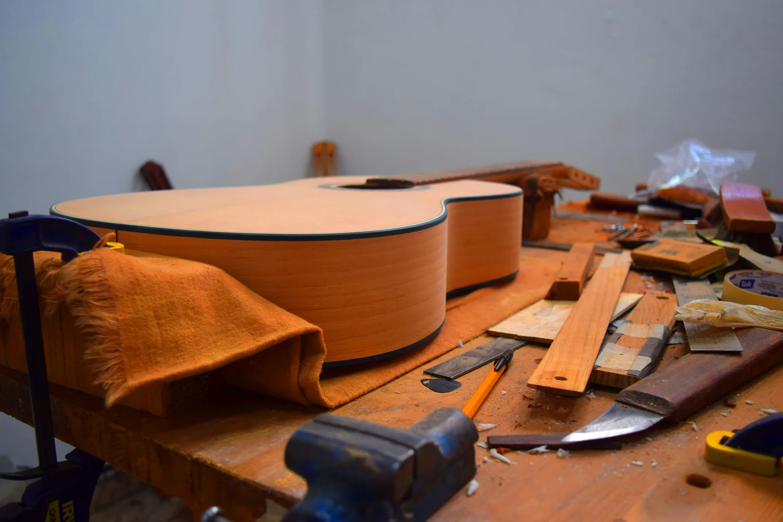 Een houten ukelele en gereedschap op een werkbank